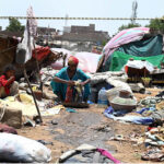 Gypsy woman washing the clothes outside her hut at Makki Shah area