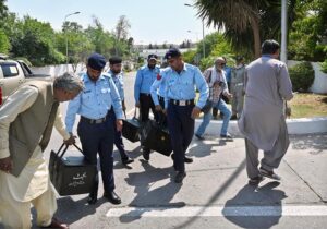 Police officials carrying bags of budget documents arrive at the National Assembly before Finance Minister Muhammad Aurangzeb presents the country's annual budget for fiscal year 2024-25.