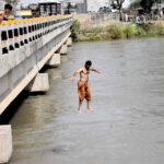 Youngsters diving in the canal to get some relief of the scorching heat in the city