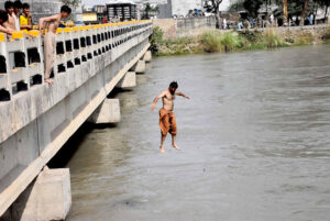 Youngsters diving in the canal to get some relief of the scorching heat in the city