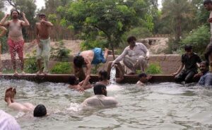 People enjoying bathing in tube well to get relief from the hot weather.