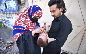 Lady Health Worker administering polio drops to a child during anti polio campaign in t Provincial Capital.