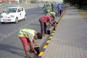 LDA staffers is busy coloring on the foot path at the roadside.