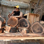 Vendors displaying wooden pieces used for meat cutting to attract customers in preparation for the upcoming Eid-ul-Azha