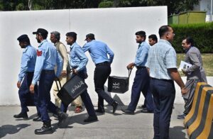 Police officials carrying bags of budget documents arrive at the National Assembly before Finance Minister Muhammad Aurangzeb presents the country's annual budget for fiscal year 2024-25.