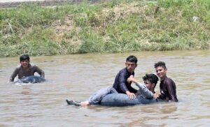 Youngsters bathing in a canal during hot day in the City.