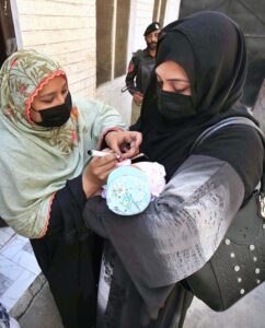 Lady Health Worker administering polio drops to a child during anti polio campaign in t Provincial Capital.