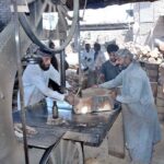 Workers busy in cutting wood into pieces with the help cutter to be used for chopping meat on the occasion of Eidul Azha at their workplace