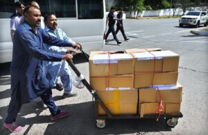 Police officials carrying bags of budget documents arrive at the National Assembly before Finance Minister Muhammad Aurangzeb presents the country's annual budget for fiscal year 2024-25.