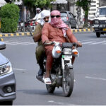 Motorcyclists covered their head and face to protect from scorching heat