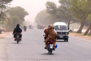 A view of people on their way during hot and dusty day in the city.