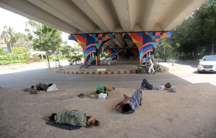 Homeless people take a rest under a bridge to protect them from the scorching heat as the city is witnessing high temperature