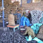 Labourers busy in packing coal in sacks for selling at his workplace