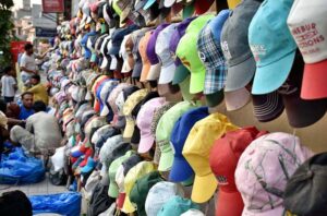A customer selecting and purchasing cap from a roadside vendor in Provincial Capital.