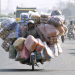 A motorcyclist on the way loaded with different items to supply on shops in different areas to earn his livelihood
