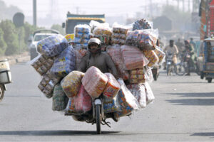 A motorcyclist on the way loaded with different items to supply on shops in different areas to earn his livelihood