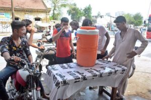 People drinking water at relief camp established by Edhi Foundation at Tower area due to scorching hot weather in Provincial Capital.