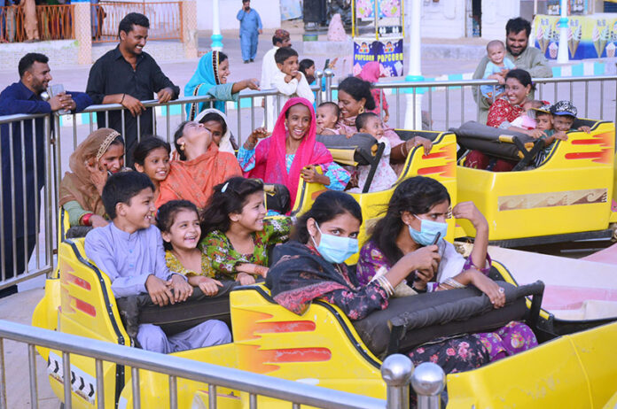 Families with children enjoying the mechanical swing ride at fun land park on the 3rd day of Eidul Azha festival