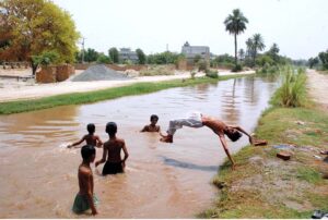 Children swim and dive into the canal, seeking relief from the intense heat