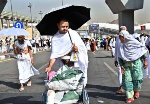Hajj pilgrims throwing pebbles at three pillars that represent Satan at Jamarat while performing Hajj ritual
