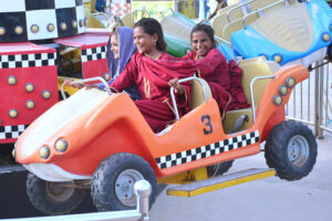Families with children enjoying the mechanical swing ride at fun land park on the 3rd day of Eidul Azha festival