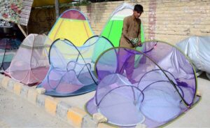 Vendor displaying mosquito net to attract customers at Double road.