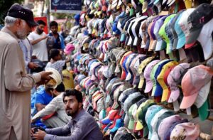 A customer selecting and purchasing cap from a roadside vendor in Provincial Capital.