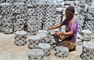 A labourer busy in arranging cemented tiles at Western Bypass.