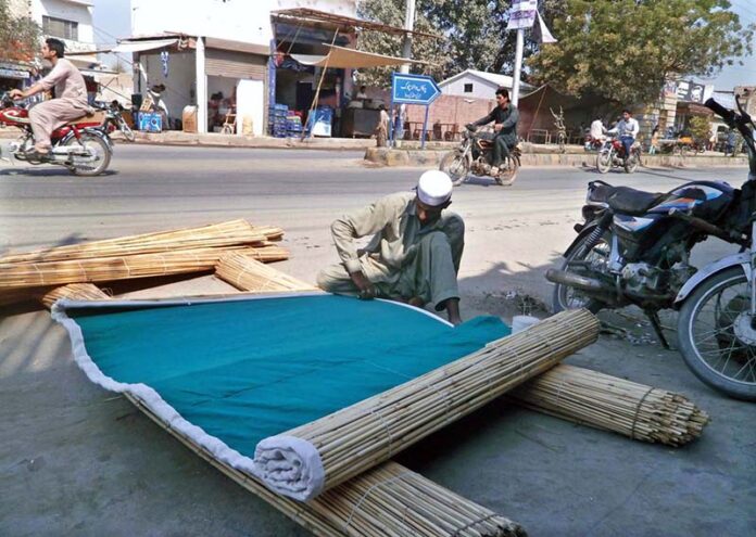 Artisan preparing traditional curtains on roadside in the City