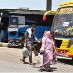 A family arrives at Pirwadhai Bus Stand to travel to their hometowns to celebrate Eid ul Azha with their loved ones