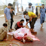 Butchers chopping meat into pieces to distribute among the people on the 2nd day of Eid-ul-Adha