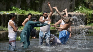 Children splashing and swimming in Korang Stream near Chak Shahzad, seeking relief from the extreme heat wave hit the federal capital as the temperature soared 42°C in federal capital