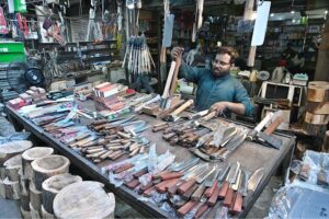 A vendor displaying knives at his shop to be used for slaughtering sacrificial animals during Eid-ul Azha in Federal Capital