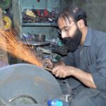 Artisan sharpening knives in ahead of Eid-ul Azah at Mission Road