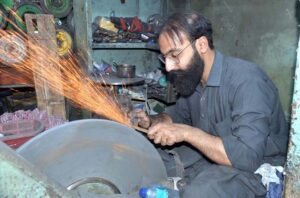 Artisan sharpening knives in ahead of Eid-ul Azah at Mission Road