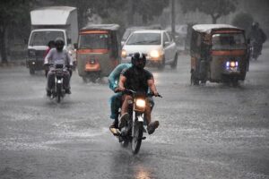 Vehicles passing through rain water accumulated on road in Kalma Chowk during heavy rain in the city.