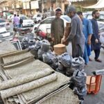 A blacksmith is sharpening knives and axes at his workplace to sell them to the butchers for using them to slaughter sacrificial animals during Eid-ul-Azha