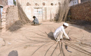 A worker making wooden baskets at his workplace.