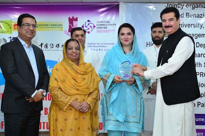 Governor KP Faisal Karim Kundi giving shield to Deputy Registrar SBBWUP Ms. Tashfeen Zia during a conference on Enhancing Regional Connectivity for the Betterment of the Shared Future of Mankind at SBBWU