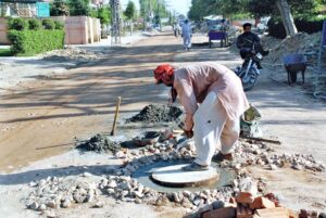 Workers repairing sewage manhole.