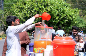 A vendor selling traditional summer drink Imli Aloo Bukharay at his roadside setup.