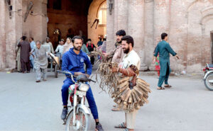 A vendor diligently sells walnut tree peel, a traditional teeth-cleaning remedy, to eager customers seeking oral hygiene solution at outside the Dehli Gate