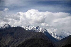 An eye catching view of clouds, hovering over the snow covered mountain in the mountain city of Pakistan.