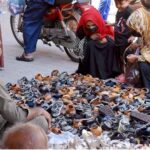 Women purchasing sandals at roadside