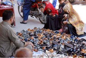 Women purchasing sandals at roadside