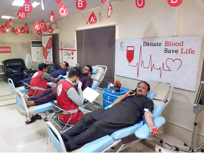Donors giving blood during Blood Donation Drive organised at Regional Blood Donor Center of Pakistan Red Crescent in connection with World Blood Donor Day 2024