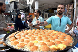 A vendor making Laddu Peethi on the roadside setup outside at Dehli Gate.