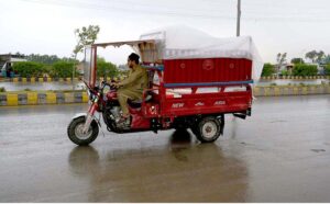 A man covered his three wheeler loader with plastic sheet to protect from rain in the Provincials Capital.