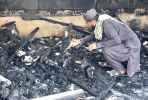 A stall holder examine the burnt remains of his stall which burnt due to yesterday’s fire at the H-9 Weekly Bazaar
