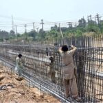 Labourers busy in construction work of flyover at under construction 10th Avenue during development work in Federal Capital